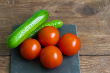 fresh cucumbers and tomatoes on wooden background