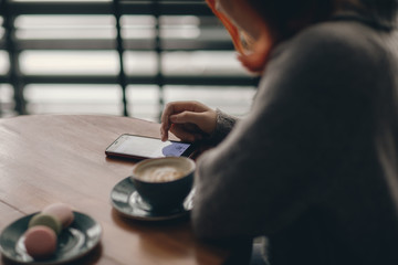  hand in the smartphone leads the screen. coffee. Cafe