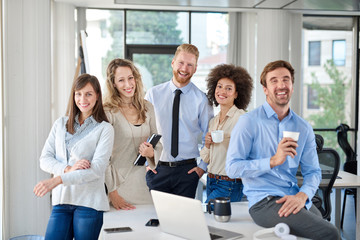 Obraz premium Small group of business people posing in office. Start up business concept. Multi ethnic group.