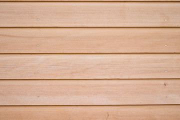 Texture of beige and brown wood planks held together by nails.