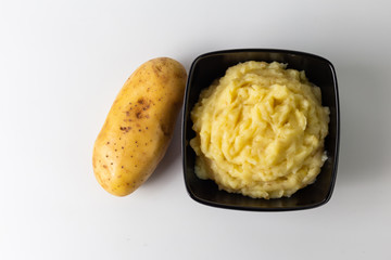 Mashed potatoes in the bowl on the white wooden table