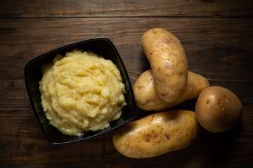 Mashed potatoes in the bowl on the white wooden table
