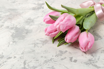 A bouquet of beautiful pink tulips flowers on a light concrete background. Spring. holidays. free space