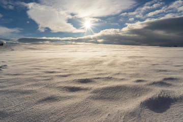 Winter landscape of hills during strong wind.