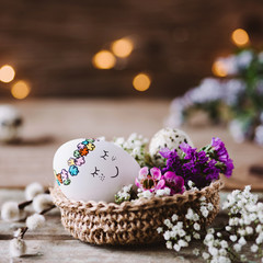 Knuddeliges Osterei im Osternest mit Blumen dekoriert