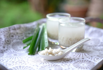Barley water in glass and cooked pearly barley with pandan leaves
