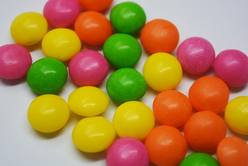 A lot of round sweets like tablets, medicine with bright color and taste. This color sweets are round beads, rainbow color stones. It's popular delicious colorful sweet with sweaty and lively form.