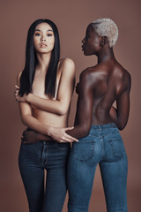 Fototapeta na wymiar Pure beauty. Attractive young topless women looking at camera while standing against brown background