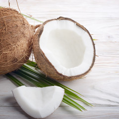 Coconut and shell pieces on white wooden table