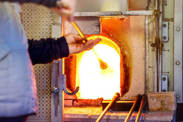 The processing of Murano glass, Venice, Veneto, Italy. A master glassmaker working with the most famous in the world murano glass with fire, crafts in manufacture. Selective focus - obrazy, fototapety, plakaty