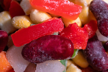 Homemade mixture of frozen vegetables, macro close-up background. Carrot, paprika, beans, green beans, onion and corn.