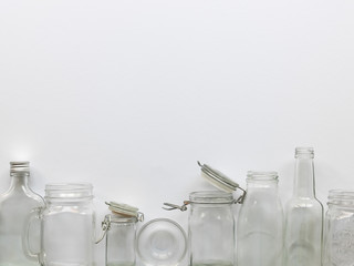 many different empty glass bottles lying on a white background, photographed from above