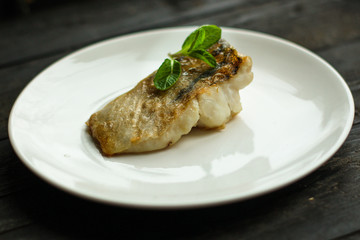 Fish, fried seafood (white fish on the plate). Food background