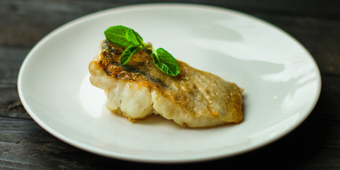 Fish, fried seafood (white fish on the plate). Food background