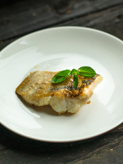 Fish, fried seafood (white fish on the plate). Food background