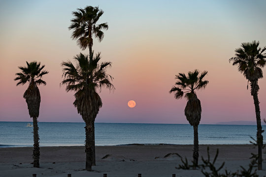 Sunrise at a California beach with a full moon setting