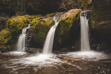 The Schiessentumpel cascade in Luxembourg is a beautiful triple waterfall under an old stone bridge