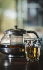 Chinese Glass teapot and cup with tea, beverage of street side dim sum restaurant. with blur background.