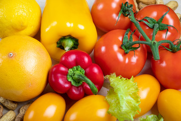 concept of healthy eating. Tomatoes, bell peppers, lettuce, lemon, nuts and grapefruit close-up