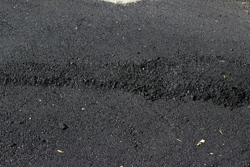 New asphalt surface with tire tracks