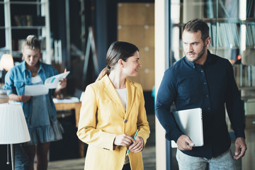 A walking meeting in the office. Man and woman employees talking about daily work
