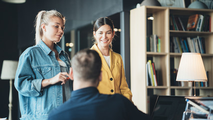Two women employees and chief manager discussing new work plans in the office