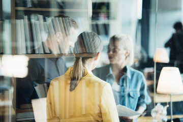 Two women employees and chief manager discussing new work plans in the office. Double exposure