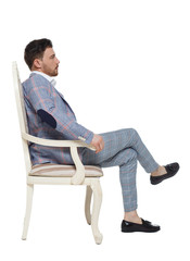 A man in a suit is sitting on an expensive chair.