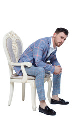 A man in a suit is sitting on an expensive chair.