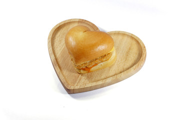 Heart shaped hamburger on wooden plate isoated on white background.