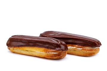 Traditional french dessert. Isolated two eclairs with custard and chocolate icing on white...