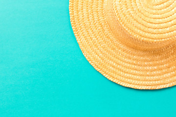 Fototapeta na wymiar Straw hat on blue background. The concept of summer.