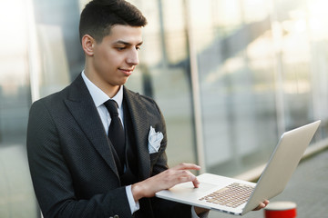 Elegant young businessman using his laptop.