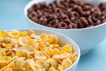 Yellow frosted corn flakes and chocolate rings bowl for dry, cereals breakfast