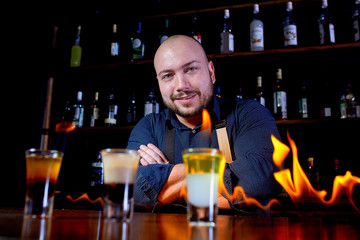 Fiery show at the bar. The bartender makes hot alcoholic cocktail and ignites bar. Bartender prepares a fiery cocktail. Fire on bar.