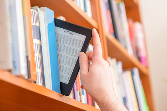 Hands holding and keeping ebook on bookshelf background