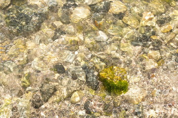 Abstract image of the water ripples over the stone pebbles - digitally altered