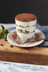 Italian dessert tiramisu closeup on wooden table, mint