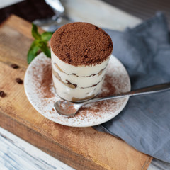 Italian dessert tiramisu closeup on wooden table, mint