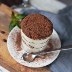 Italian dessert tiramisu closeup on wooden table, mint