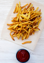 French fries with ketchup on white wooden background, top view. Flat lay, overhead, from above.