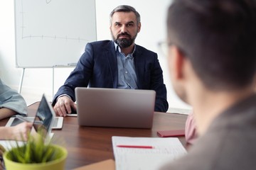 Business meeting. Two business people sitting in front of each other in the office while discussing something.