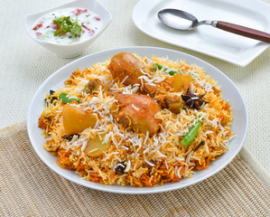Chicken Biryani, A famous Indian Sub-continent savory rice dish mixed with spicy marinated chicken, spices and flavorful saffron.