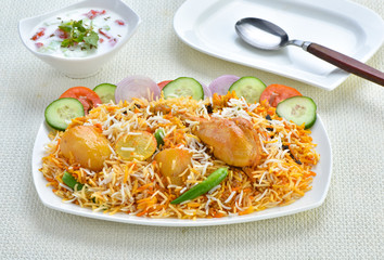 Chicken Biryani, A famous Indian Sub-continent savory rice dish mixed with spicy marinated chicken, spices and flavorful saffron.