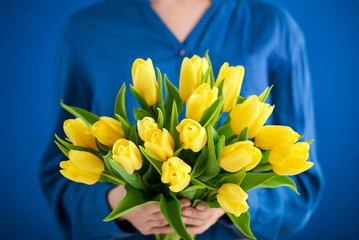 Bunch of tulips in woman's hands, shallow dof.