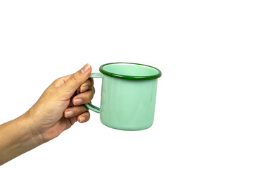 Female hands holding green tin cup on white background.