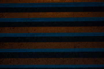 Marble pedestrian steps illuminated with blue and yellow light with shadows