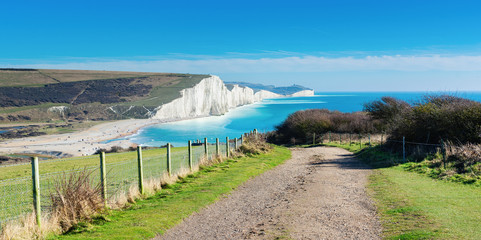Walk to Cuckmere Haven beach near Seaford, East Sussex, England. South Downs National park. View of blue sea, cliffs, long photo banner selective focus - obrazy, fototapety, plakaty