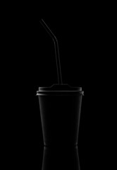 Black paper cup with a lid and a straw. On a black background. - 251396572