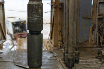 Offshore oil rig worker prepare tool and equipment for perforation oil and gas well at wellhead platform. Making up a drill pipe connection. A view for drill pipe connection from between the stands.